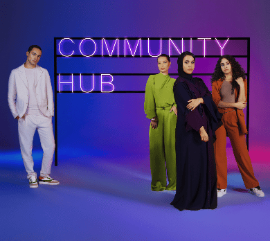 Three women and a man standing in front of a signboard for the Community Hub coworking space